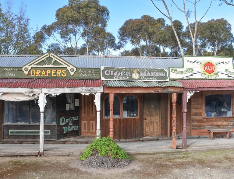 Vintage storefronts for a draper, clockmaker, and radio store at Old Tailem Town pioneer village.