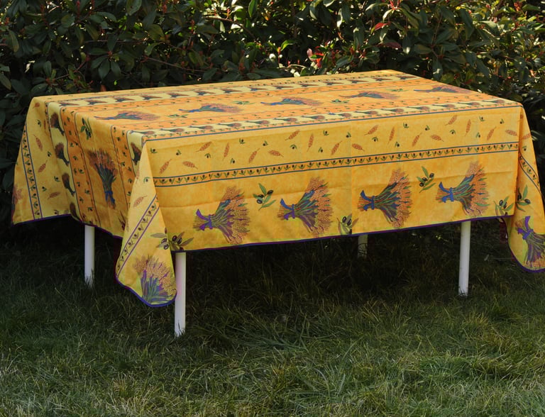 Une nappe avec une nappe provençal jaune par dessus