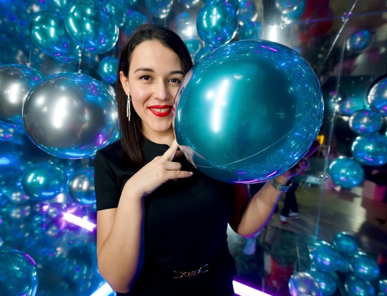 cabina espejada para eventos en Mallorca con invitada posando entre globos