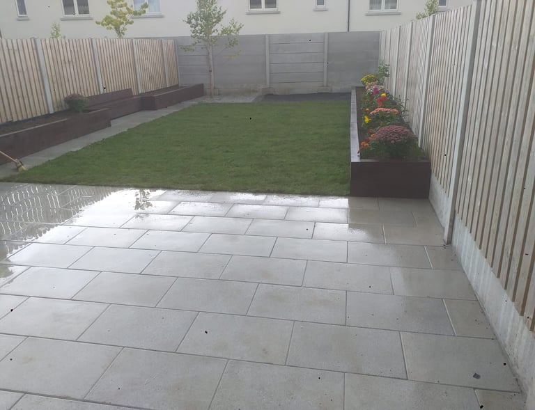 The after picture of the backyard patio with a large lawn