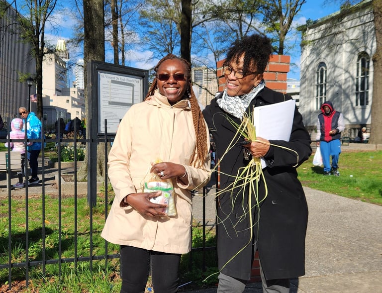 two people standing in front of a fence holding hygiene kits