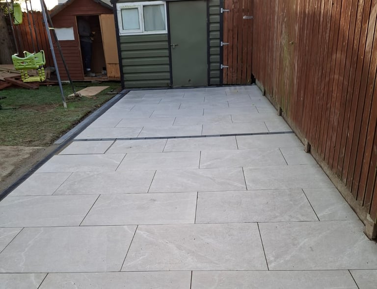 a patio with a concrete patio with a wooden fence