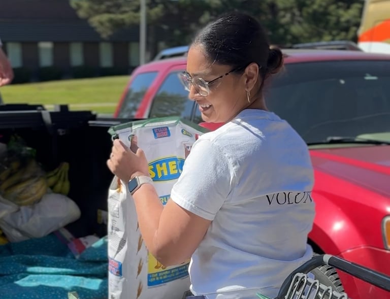 Volunteer smiling while at communtiy food delivery event