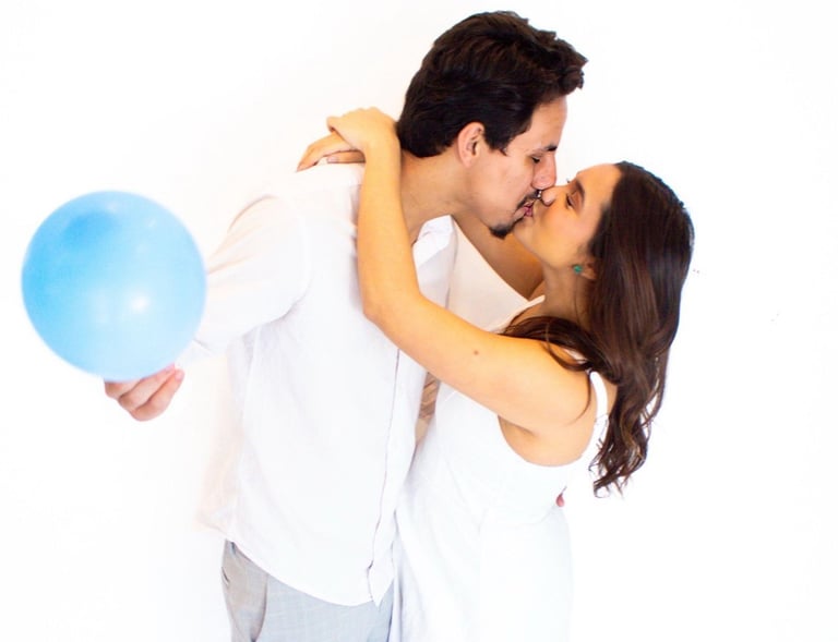 a man and woman kissing in front of balloons