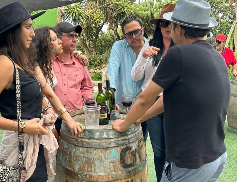 Grupo de amigos conversando junto a barril en viñedo de Querétaro