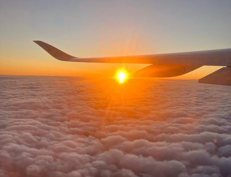 Airplane soaring above the clouds at sunset, capturing breathtaking sky views and travel adventure