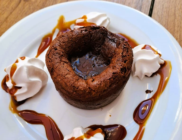 Coulant de chocolate que refleja la historia del Bar Las Tinajas Huelva, con presentación cuidada y sabor tradicional.