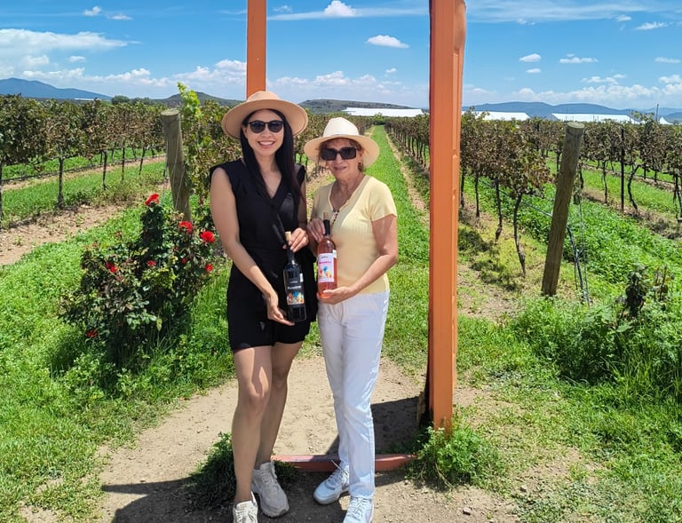 Dos mujeres con botellas de vino en viñedo de Querétaro, experiencia enológica