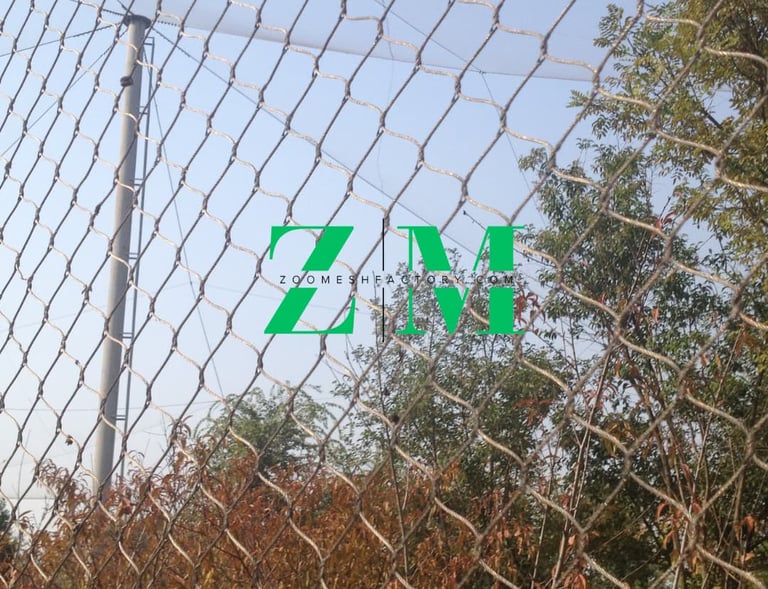 Durable stainless steel wire rope mesh fencing installed outdoors for zoo enclosures and safety netting.