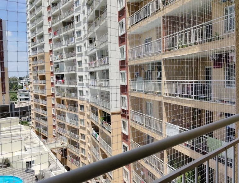 Close-up of a freshly installed pigeon safety net on a balcony in Bengaluru, showing the fine mesh a
