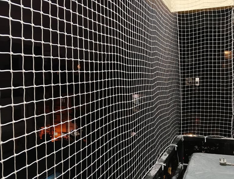 Close-up of a sturdy balcony pigeon net securely installed on a BTM Layout apartment balcony.