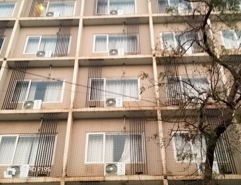 Evening view of a balcony with safety netting softly illuminated by warm lights.