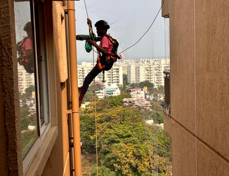 Technician from Sukumari Safety Nets carefully measuring a window frame before installing the pigeon