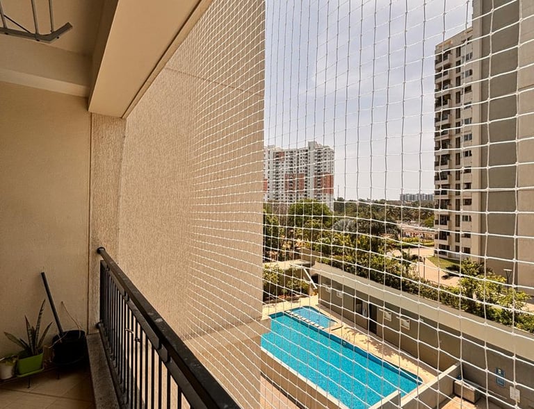 Wide shot of a residential building with multiple pigeon safety nets installed on windows and terrac