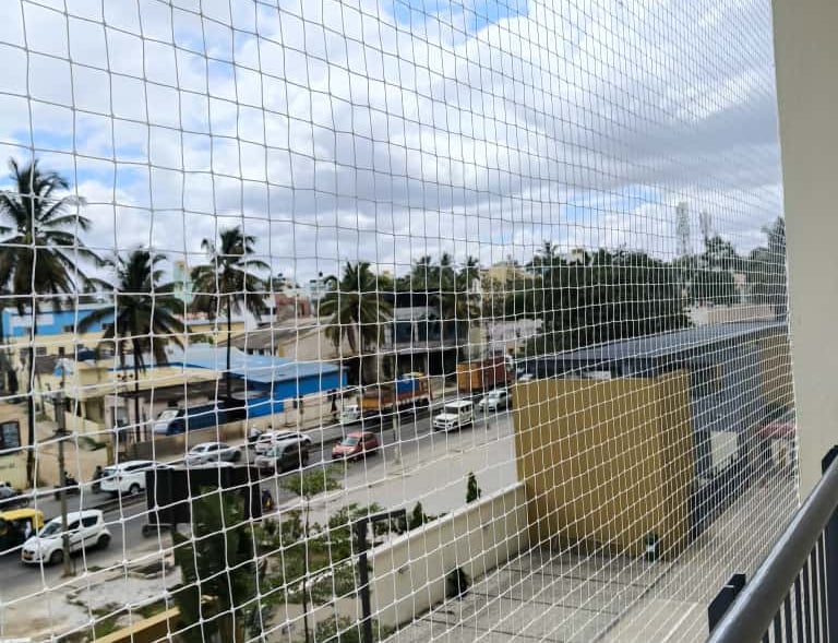 Installation team from Arjilli Enterprises fitting a safety net on a residential balcony in T Nagar.