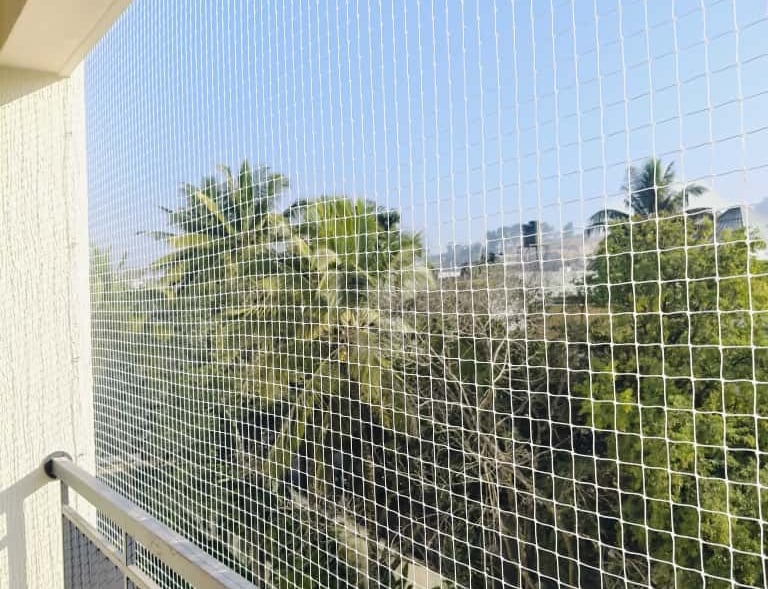 Close-up of a securely installed balcony safety net protecting a child playing nearby.