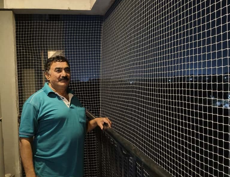 Installation team from Arjilli Enterprises fitting a staircase safety net with care and precision.
