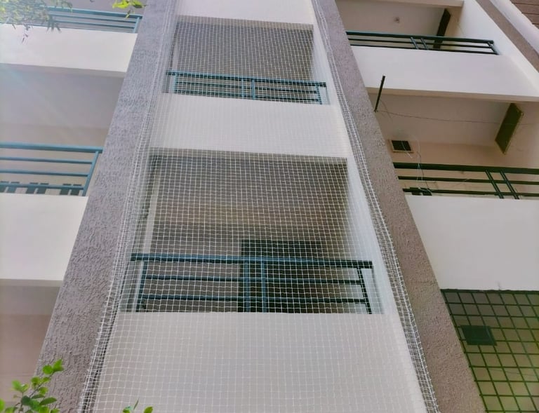 Close-up of a tightly woven anti-pigeon net installed on a Mylapore balcony.