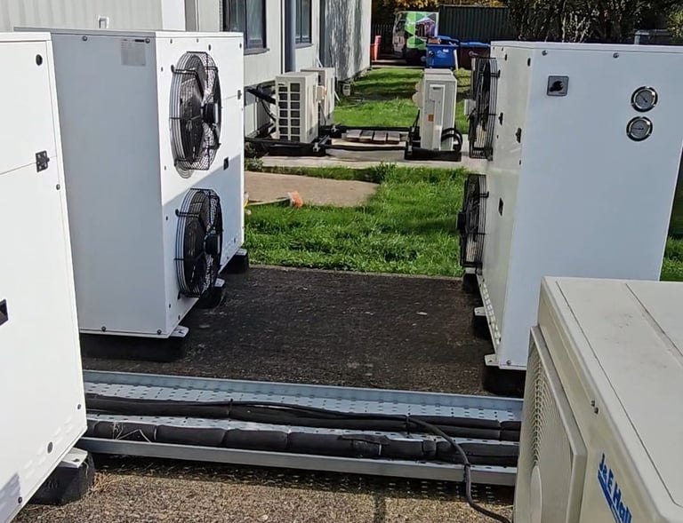 a group of refrigerators and spilit cooling units in a yard