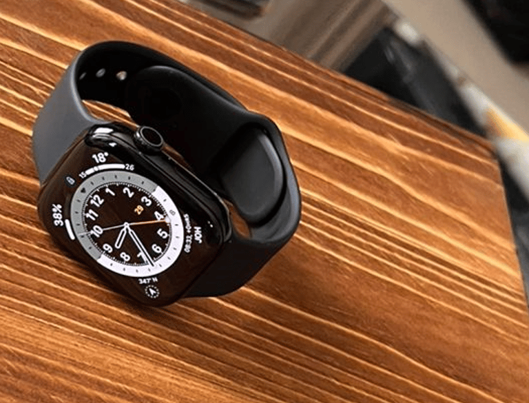Close-up of a sleek, modern smartwatch resting on a wooden table.