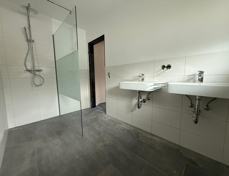 ein renoviertes Bad mit hellen und dunklen Fliesen