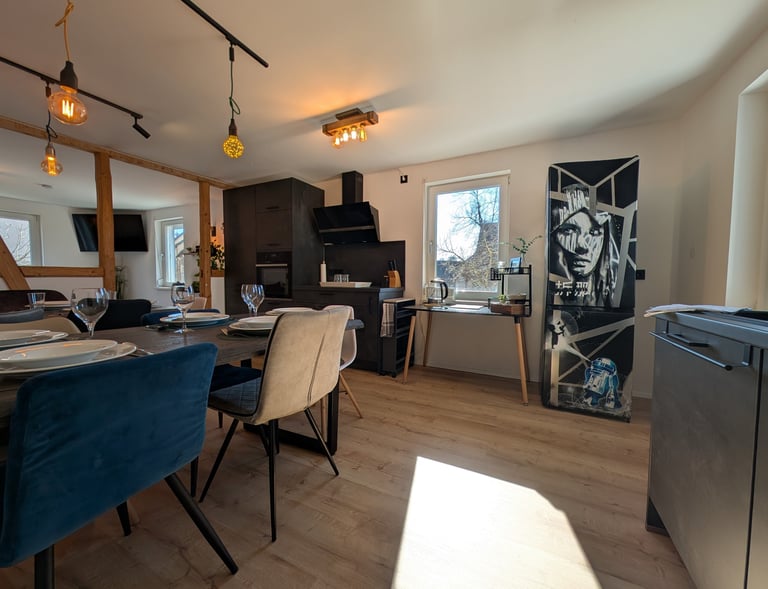 eine moderne, sanierte, schwarze Küche mit hellem Vinylboden und Fachwerk