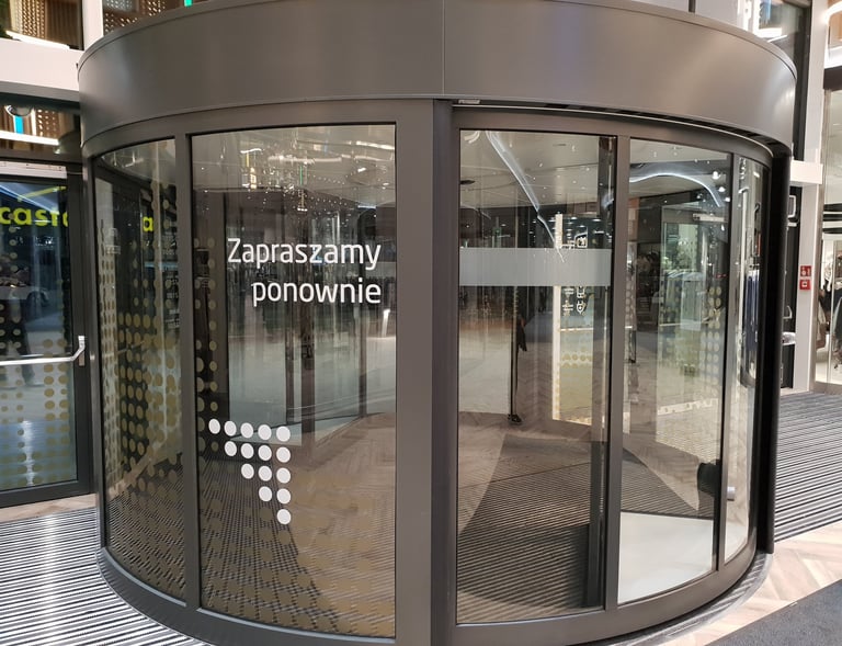 drzwi obrotowe w galerii handlowej z naklejkami