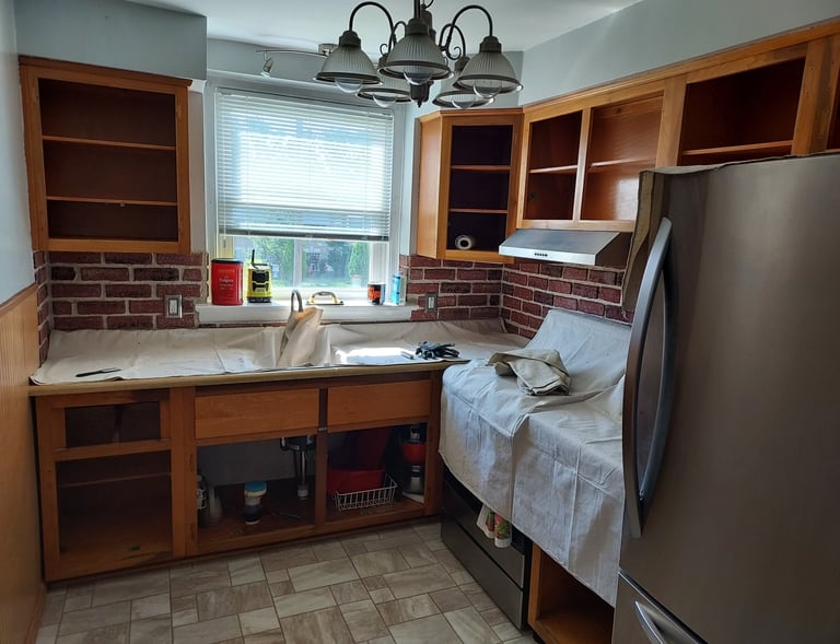 a kitchen with drop colthes on conter top