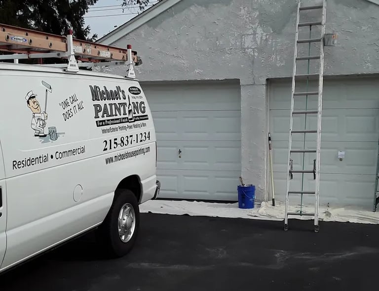 a van in a driveway with ladders on a garage