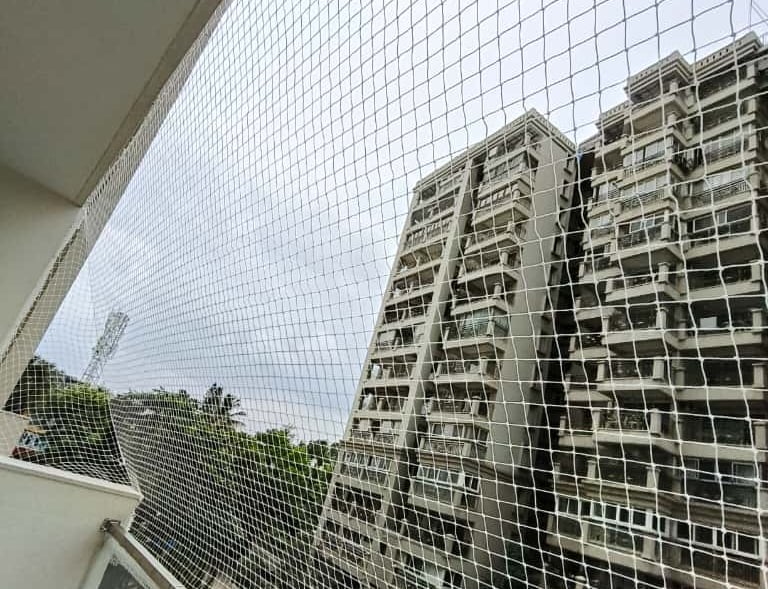 Wide shot showing the safety nets securing multiple balconies in a Basavanagudi residential building