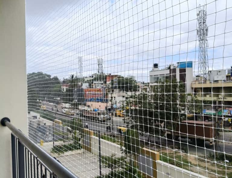 Side view of a balcony safety net installation in progress, highlighting the quality materials used.