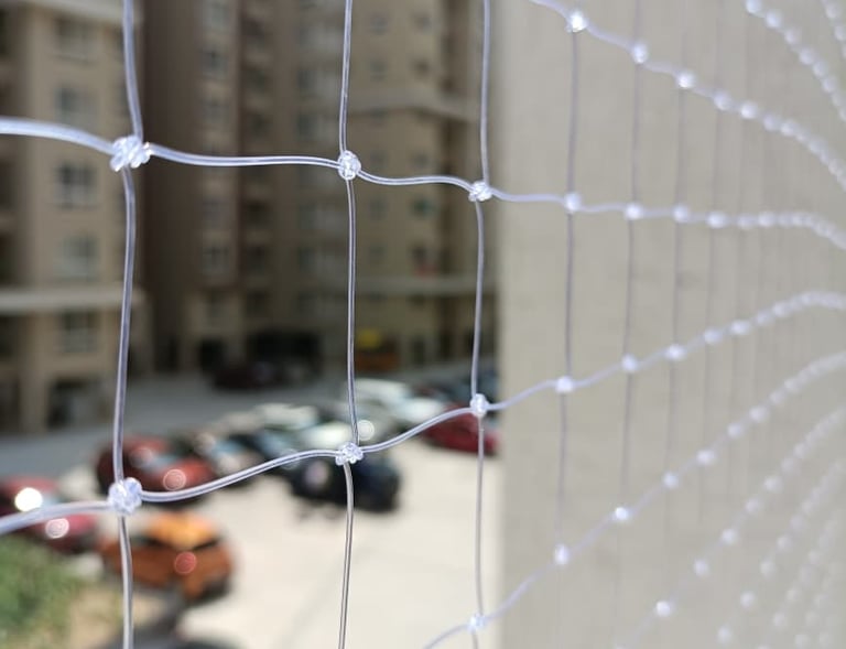 Close-up of the durable net material with sunlight filtering through on a Basavanagudi balcony.