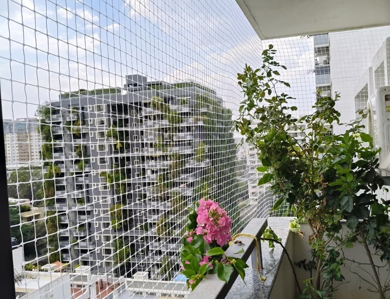 Daylight view of a balcony protected by tightly woven safety netting against pets and children.