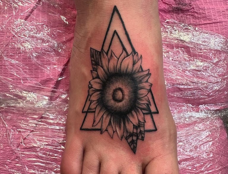 a tattoo style sunflower tattoo on the foot of a woman's foot