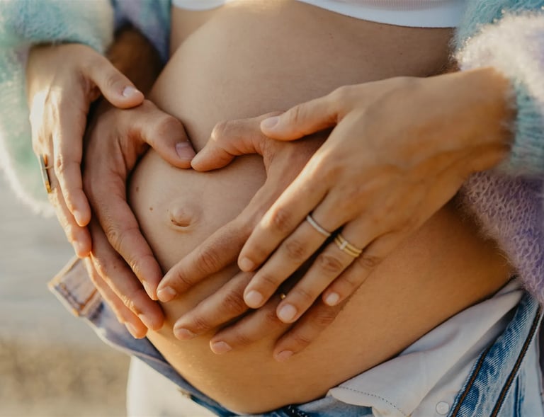 Mains des parents formant un cœur sur le ventre rond – photo de grossesse tendre dans le Gard