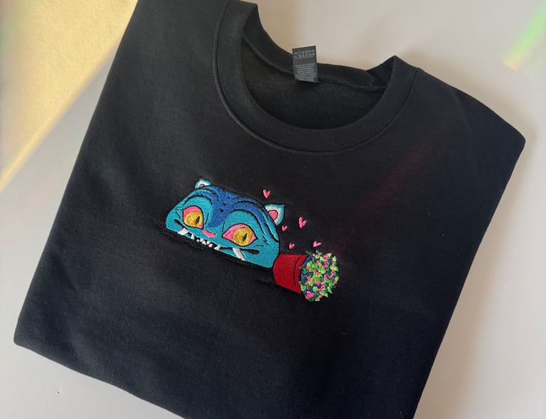 a black sweatshirt with a blue cat embroidered on it