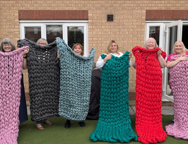 a group of people holding up blankets and blankets