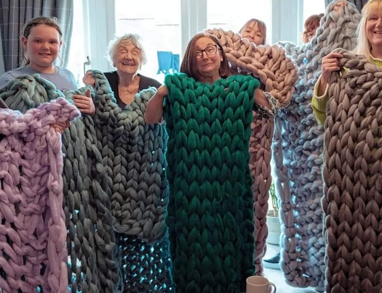 a group of people holding up blankets and blankets
