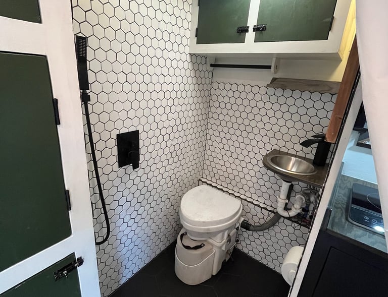 tiled shower inside epic overlanding rig, composting toilet, small sink and rainfall showerhead