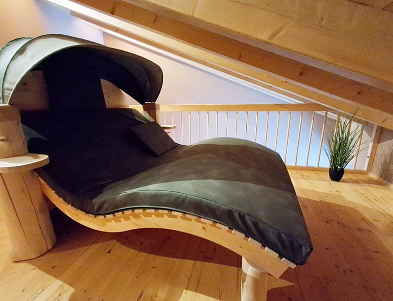 breite Sauna-Liege mit Haube und echten Stämmen