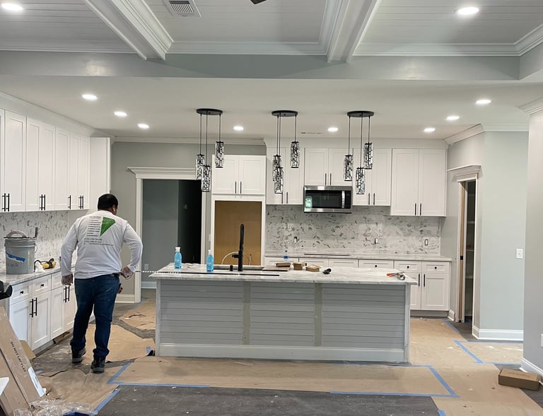 A worker wearing a Garnet Painting shirt working on a kitchen remodel.