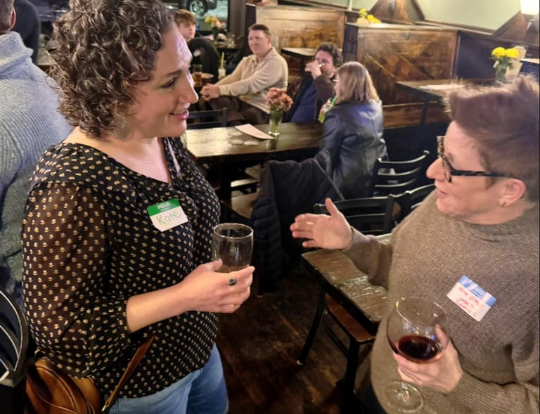 two women speaking at a bar