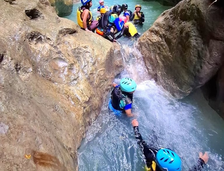 a group of people in helmets canyoneering
