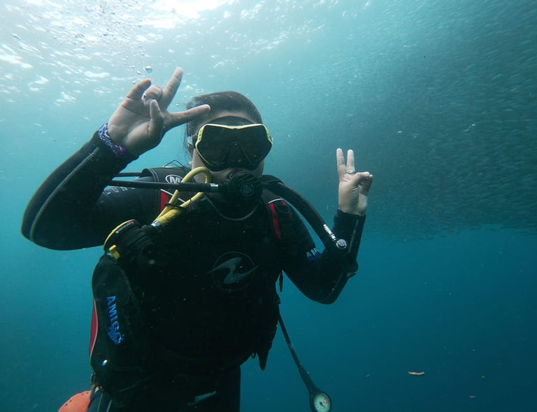 Girl in a scuba suit and scuba goggles in the water