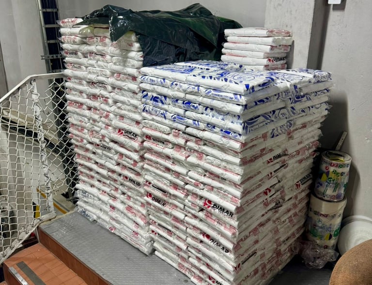 Stacks of white plastic sacks filled with materials in a storage area or warehouse.