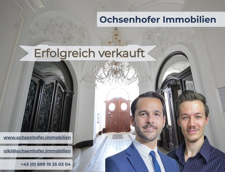 Two real estate agents from Ochsenhofer Immobilien in front of a luxury apartment hallway.