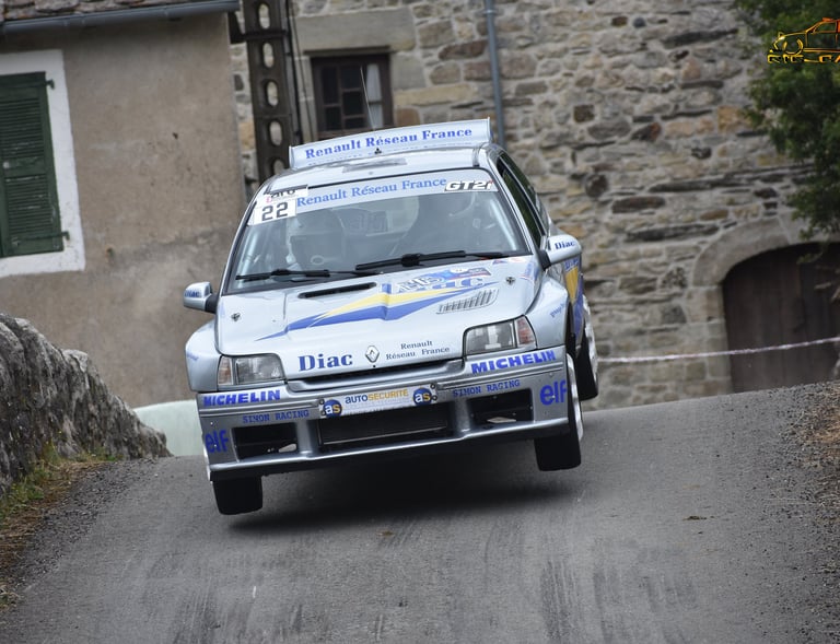 Une Renault Clio Maxi aux couleurs d'origine "diac" en plein saut lors du rallye de Bagnols les Bain