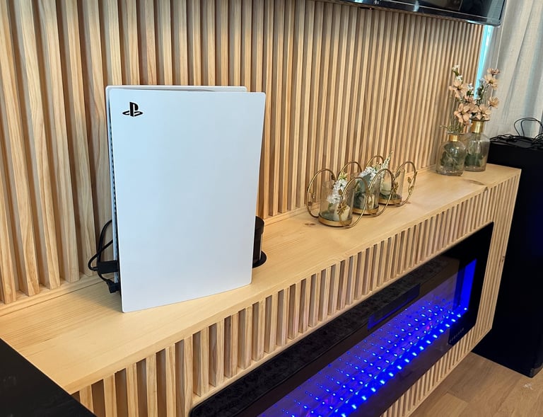 Modern wood slat entertainment center with blue electric fireplace.