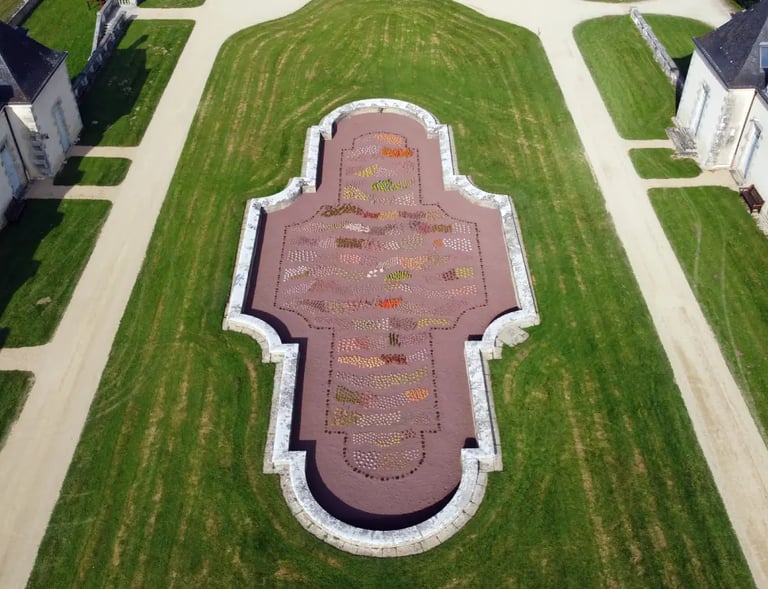 Vue aérienne d'un jardin formel géométrique avec des allées de pelouse symétriques et un parterre de