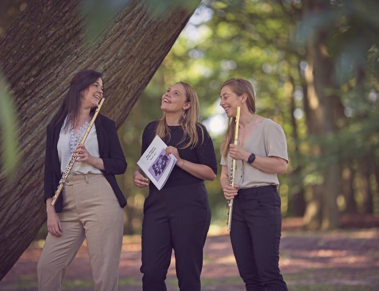 three women playing flute and flute in a wooded area